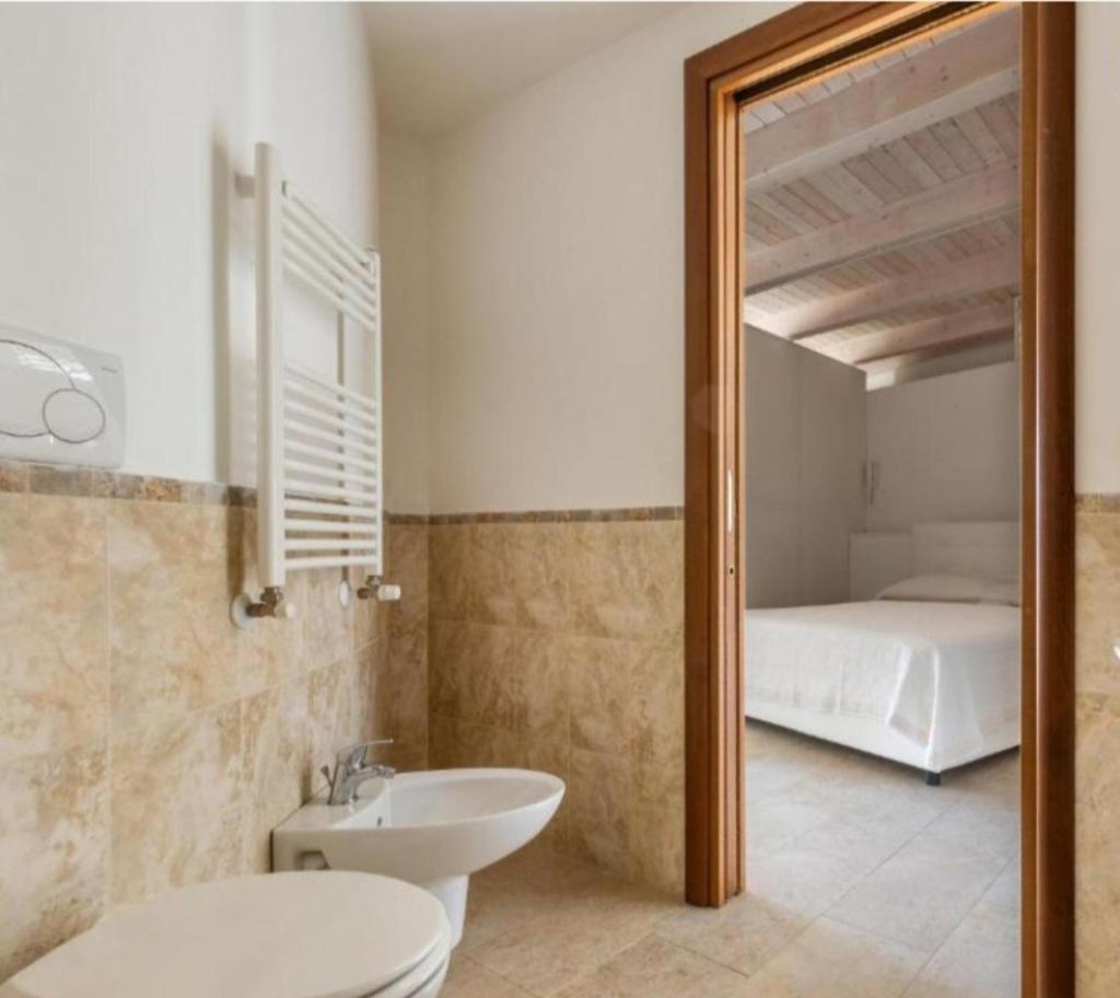 une salle de bain avec toilettes et lavabo et un lit dans l'établissement Trullo Monte Cannone con piscina, à Cocolicchio