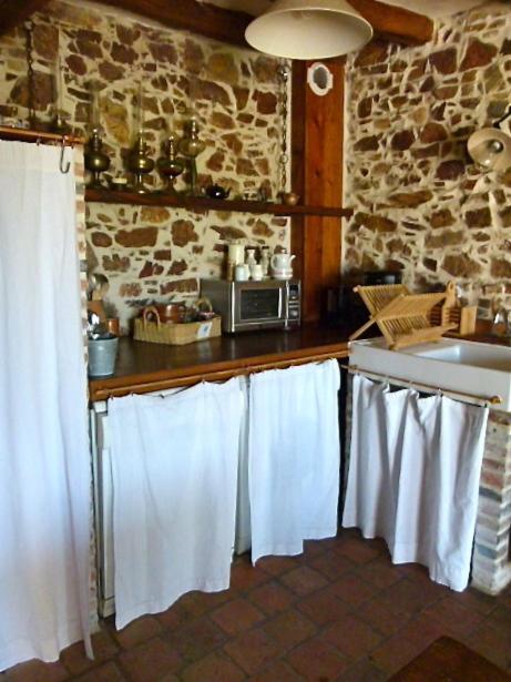 - une cuisine avec des serviettes blanches suspendues au comptoir dans l'établissement Gites De L'Etang Des Noues, à Cholet