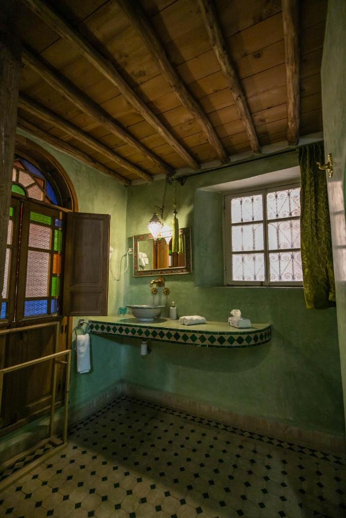 La salle de bains verte est pourvue d'un lavabo et d'une fenêtre. dans l'établissement Riad Les Idrissides Chez LEA, à Fès