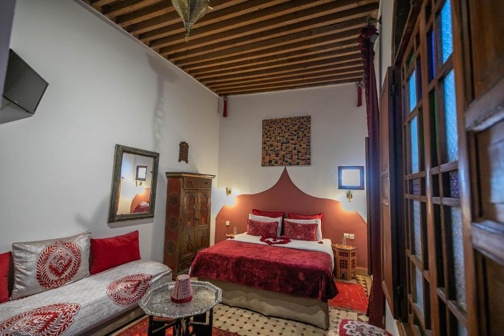 une chambre avec un lit et un canapé dans l'établissement Riad Les Idrissides Chez LEA, à Fès