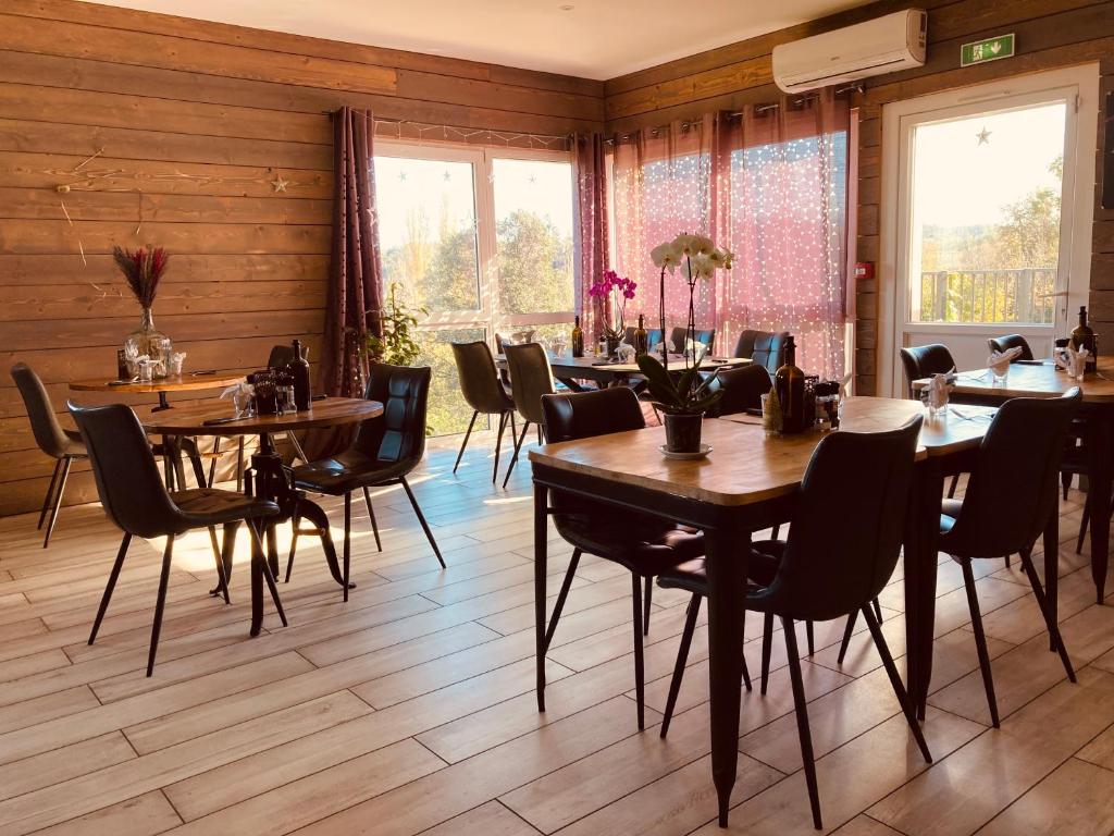 une salle à manger avec des murs en bois, des tables et des chaises dans l'établissement Lodges du Ushuaïa Villages Camping les 4 Saisons, à Grane