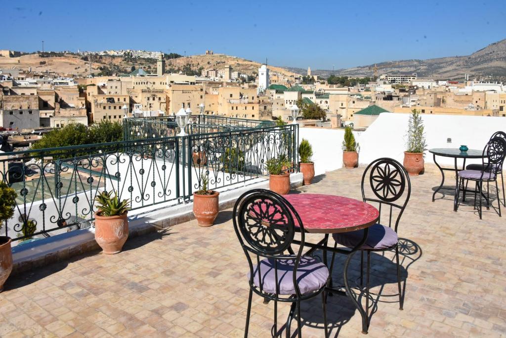 un patio avec une table et des chaises sur un balcon dans l'établissement Riad Fes EL KAID, à Fès