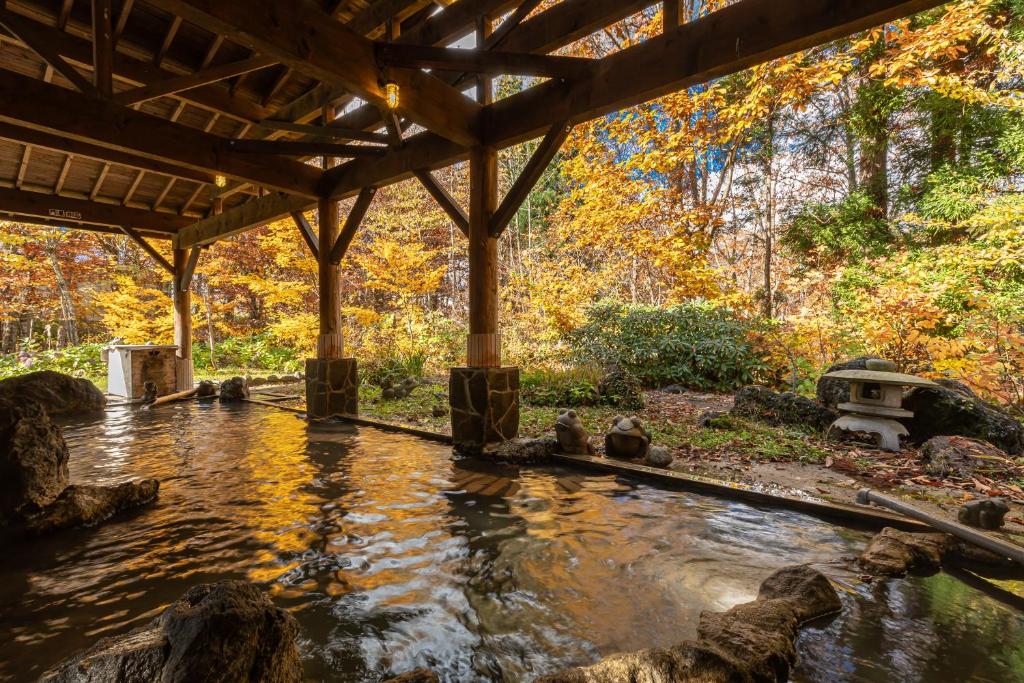 un étang au milieu d'un jardin dans l'établissement KAMENOI HOTEL Tazawako, à Senboku