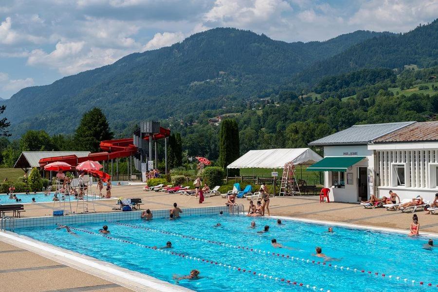 une grande piscine avec de nombreuses personnes dans l'établissement Charmant mobilhome à 2 pas remontés ski Samoëns, à Samoëns