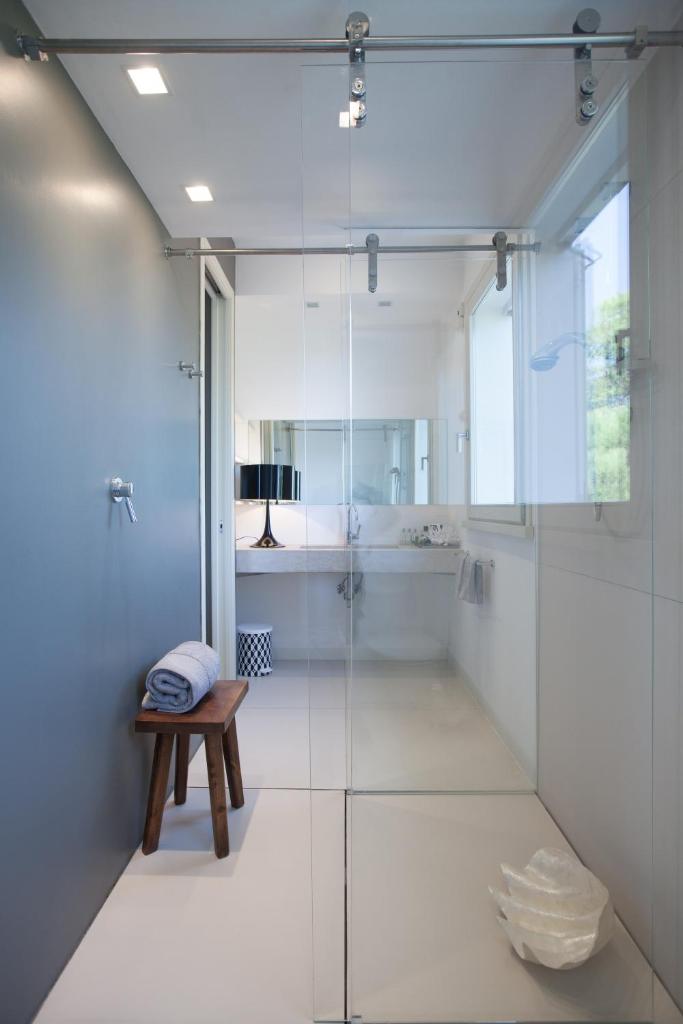 une salle de bain avec une douche en verre et un banc dans l'établissement Villa Belvedere, à Bertinoro