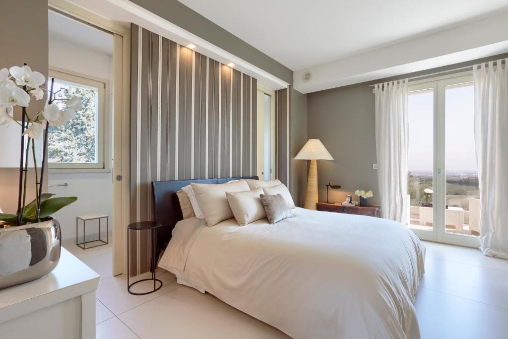 une chambre avec un lit blanc et une grande fenêtre dans l'établissement Villa Belvedere, à Bertinoro 37 autres photos