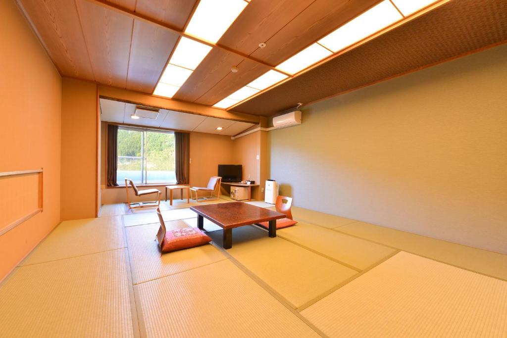 un salon avec une table et des chaises dans une pièce dans l'établissement Ooedo Onsen Monogatari Hotel Kinugawa Gyoen, à Nikkō