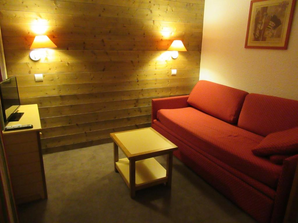 un salon avec un canapé rouge et une table dans l'établissement Appartement 644 au pied des pistes de Belle Plagne, à La Plagne Tarentaise