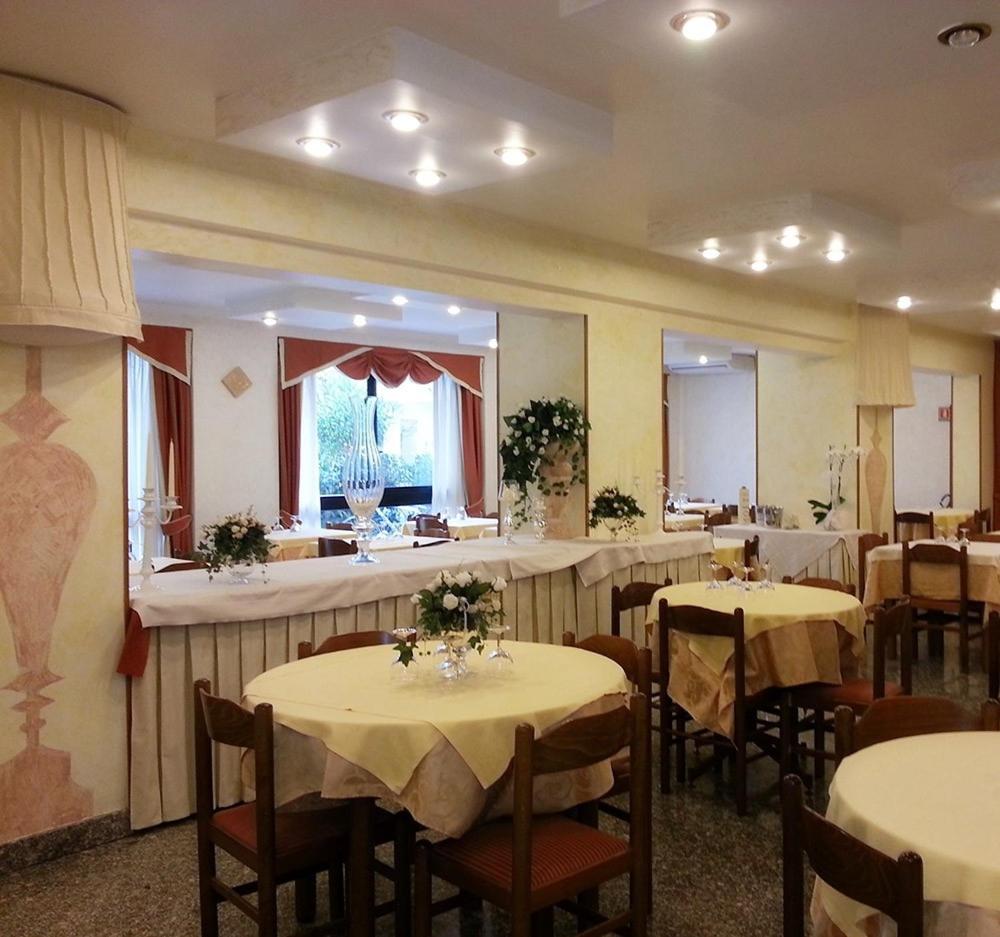 une salle à manger avec des tables et des chaises avec des fleurs dessus dans l'établissement Hotel Corallo, à Giulianova