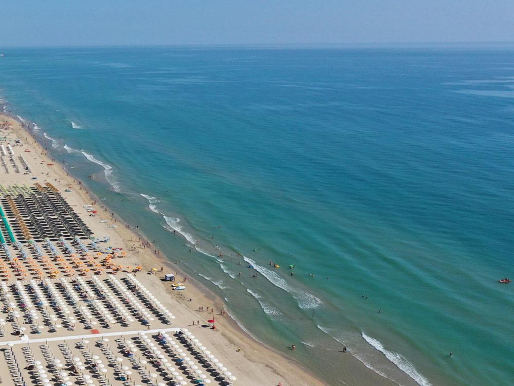 une vue aérienne d'une plage avec des chaises et l'océan dans l'établissement Hotel Corallo, à Giulianova