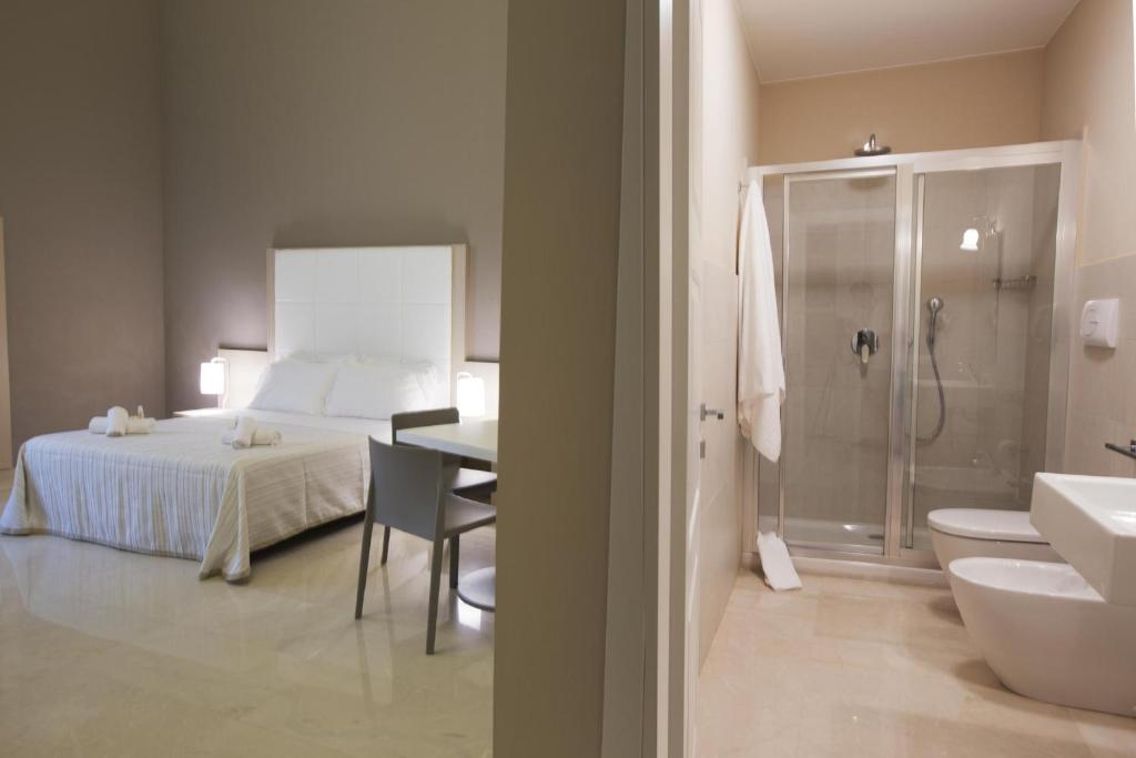 une chambre avec un lit et une salle de bain avec douche dans l'établissement Central Gallery Rooms- Palazzo D'Ali' Staiti XIX, à Trapani