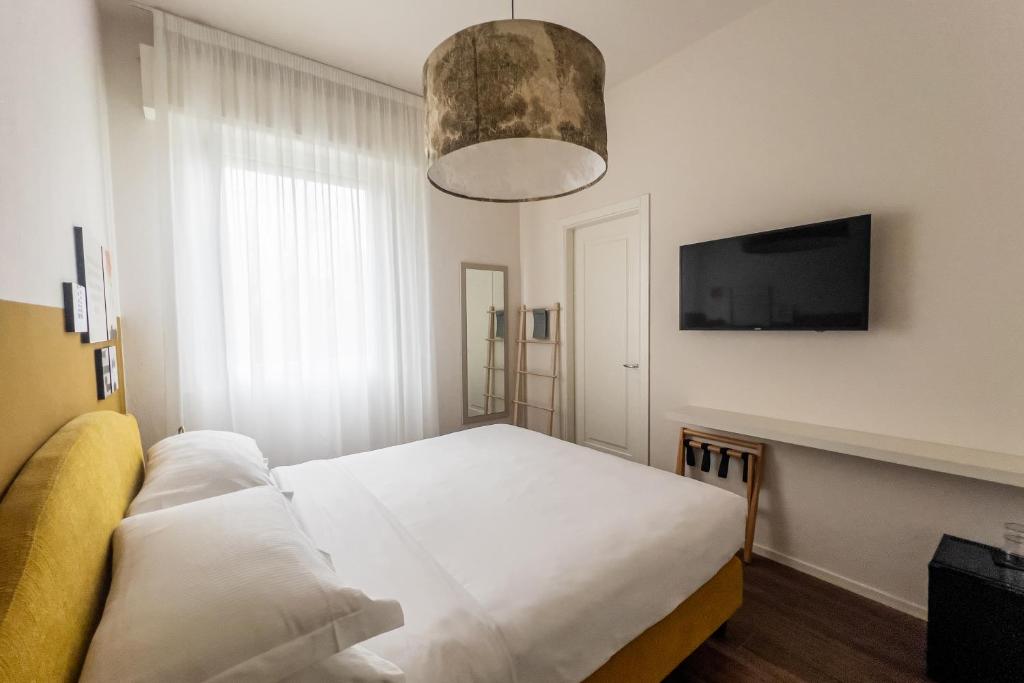 une chambre avec un lit et une télévision à écran plat dans l'établissement Lu. b&b, à Cervia