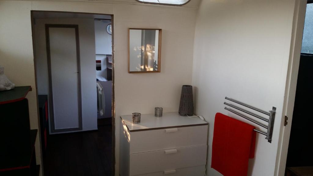 Cette chambre comprend un comptoir avec une chaise rouge et un miroir. dans l'établissement Botel La Vecchia (LY1992), à Dole