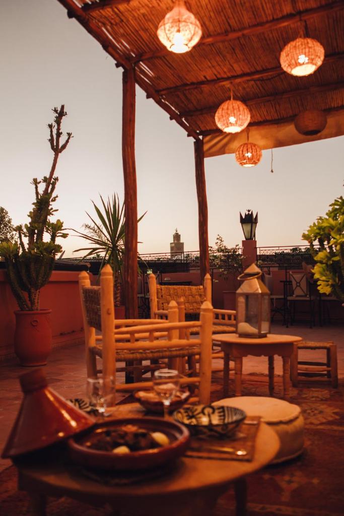 une table et des chaises sous une pergola en bois dans l'établissement Riad Bensaid, à Marrakech