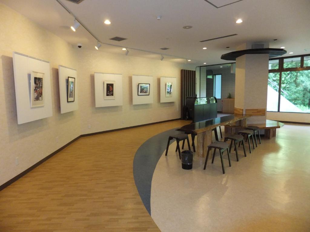 Cette chambre comprend un bar avec des chaises et des peintures murales. dans l'établissement 田沢湖水沢温泉郷セルリアンリゾートAoni, à Senboku 35 autres photos
