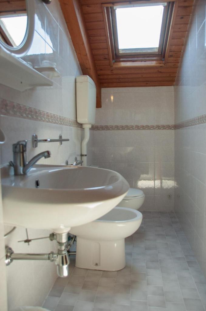 une salle de bain avec un lavabo et des toilettes dans l'établissement Albergo Villa Miraggio, à Rimini