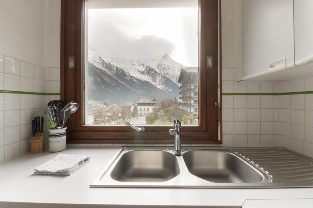 d'un évier de cuisine avec une fenêtre offrant une vue sur la montagne. dans l'établissement Makalu - View Mont-Blanc - Chamonix Center -8 pers, à Chamonix-Mont-Blanc
