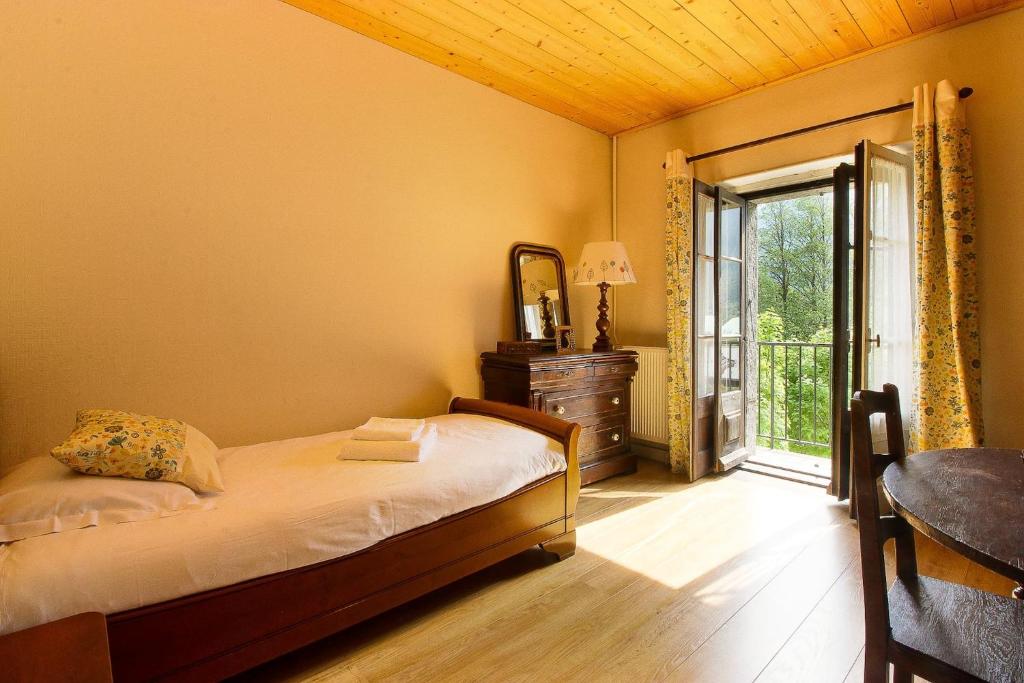 une chambre avec un lit et une porte coulissante en verre dans l'établissement Maison Emile Devouassoud, à Chamonix-Mont-Blanc