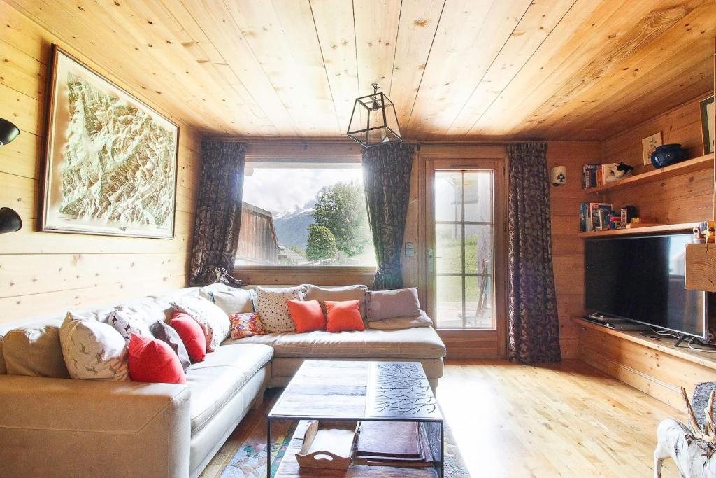 un salon avec un canapé et une télévision dans l'établissement Maison Neuve - Grand appartement- Terrasse - Vue sur la vallée du Mont-Blanc, aux Houches