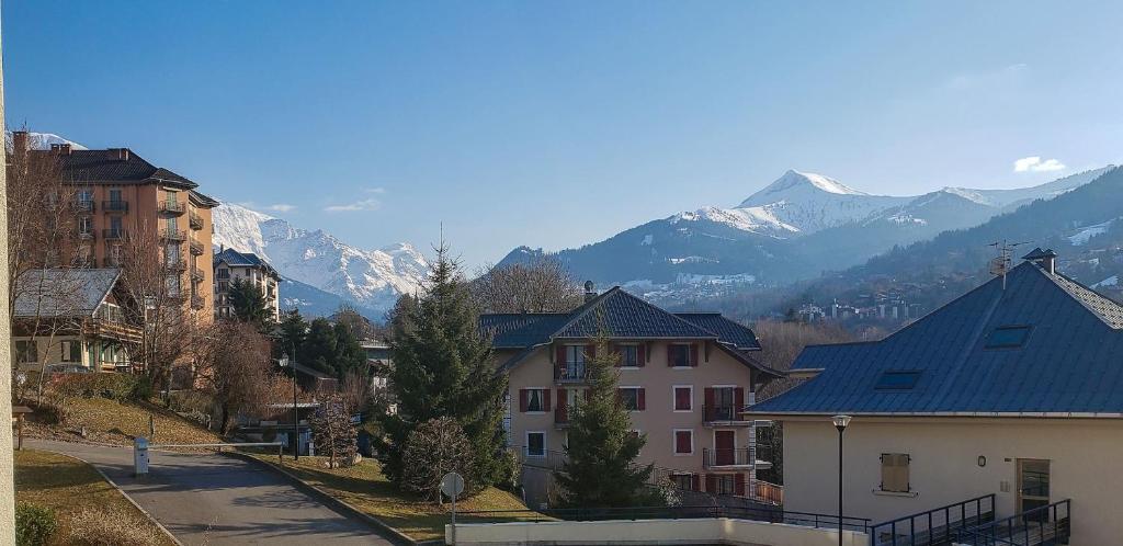 un groupe de bâtiments avec des montagnes en arrière-plan dans l'établissement Appartement L'Armancette - Proche centre et Bettex, à Saint-Gervais-les-Bains