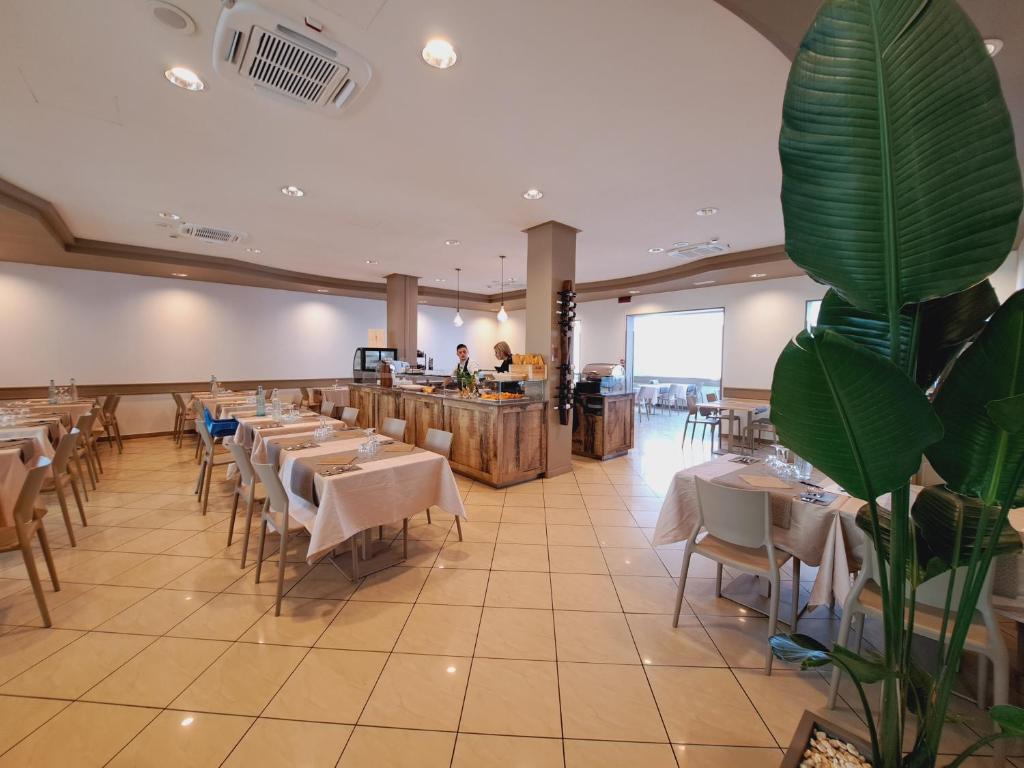 un restaurant avec des tables et des chaises et un bar dans l'établissement Hotel Butterfly Wellness & Spa, à Rimini