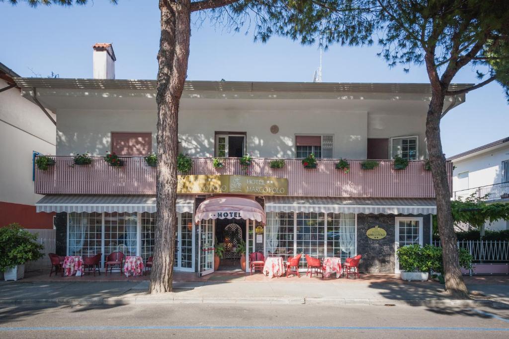- un balcon avec des tables et des chaises dans l'établissement Hotel Marco Polo, à Lignano Sabbiadoro