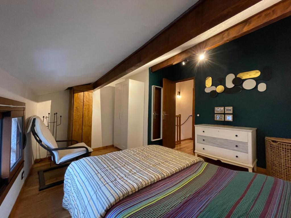une chambre avec un lit et une chaise dedans dans l'établissement Maison village proche Andorre et stations de ski, à Porté-Puymorens