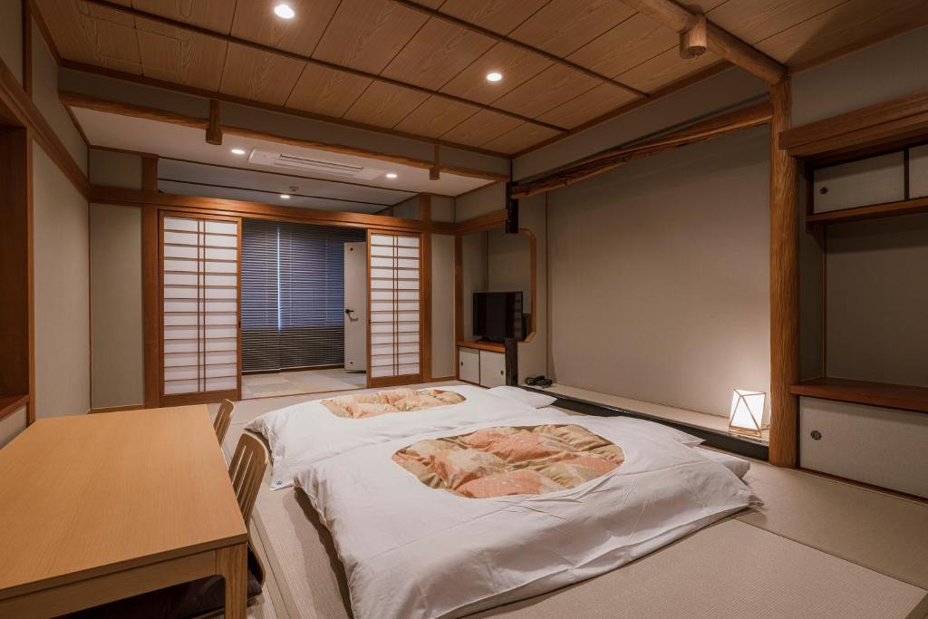 - une chambre avec un lit dans une chambre avec un bureau dans l'établissement Shinzan Kinosaki, à Toyooka