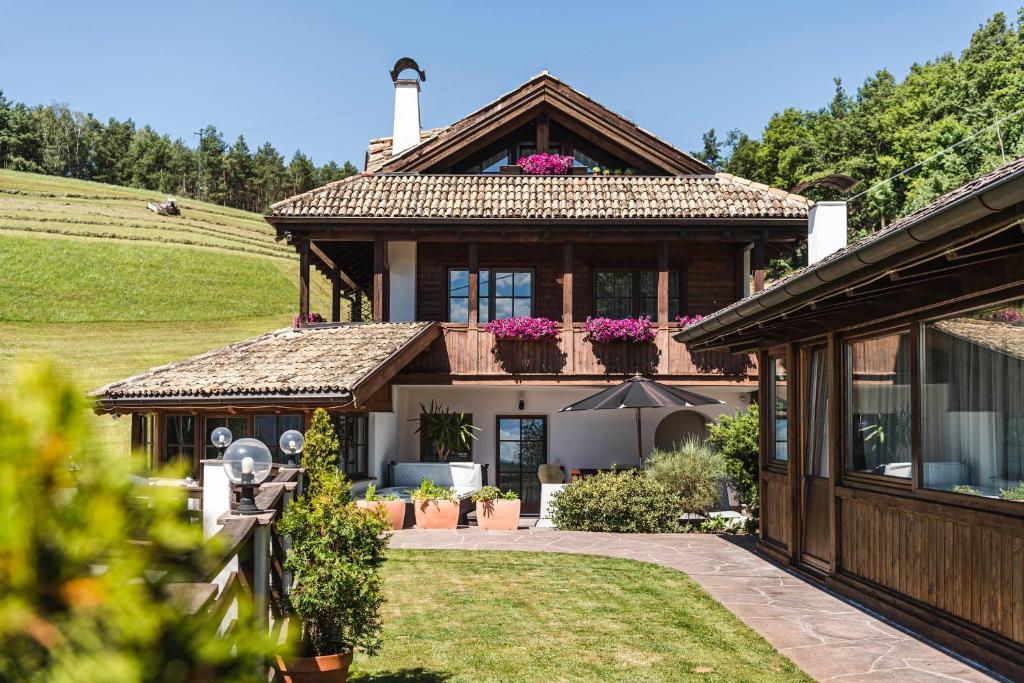une maison avec une véranda et un toit dans l'établissement Exclusive Chalet Grumer 700 sqm, à Soprabolzano