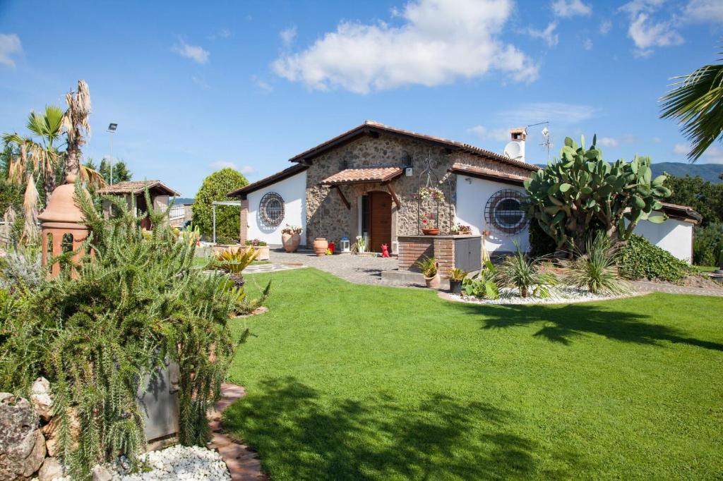 une maison avec une pelouse verte devant dans l'établissement Villa Antici by PosarelliVillas, à Velletri