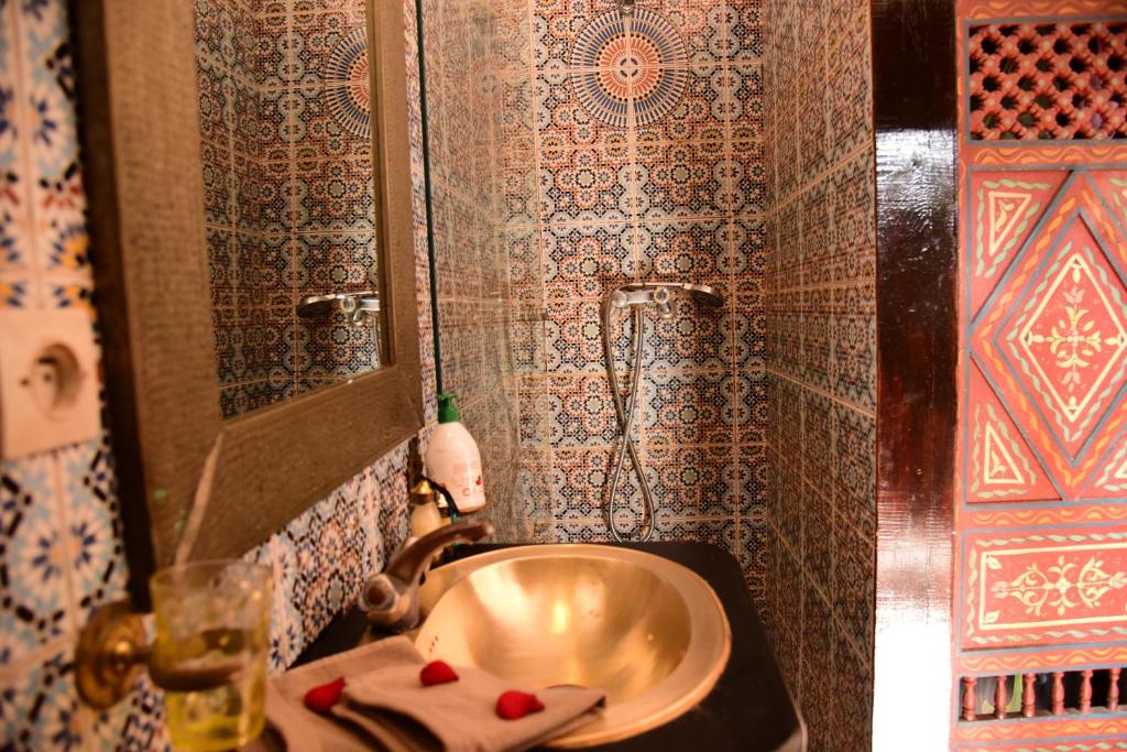 une salle de bain avec un lavabo et un miroir dans l'établissement Riad Du Petit Prince, à Marrakech