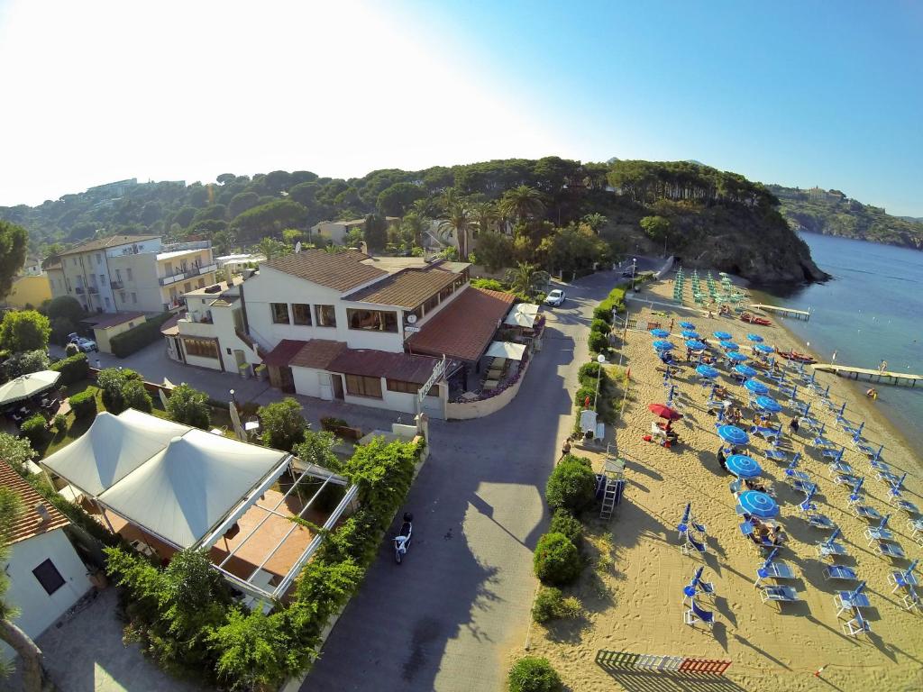 une vue aérienne d'une plage avec parasols et chaises dans l'établissement Frank's Hotel, à Capoliveri