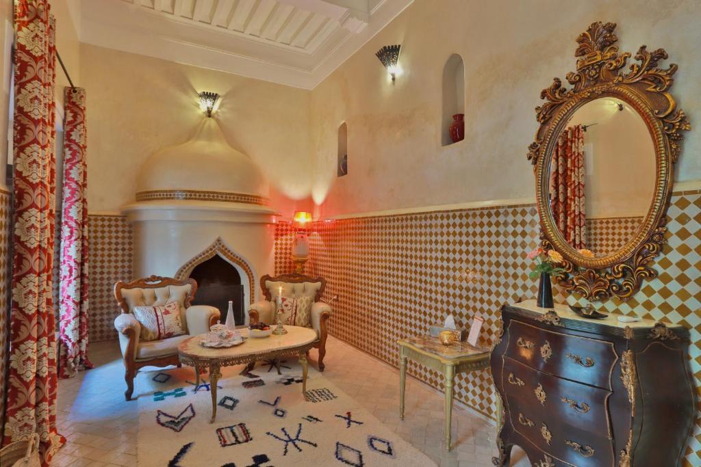 - un salon avec une table et un miroir dans l'établissement Riad ABBASSIA Marrakech Premiere, à Marrakech