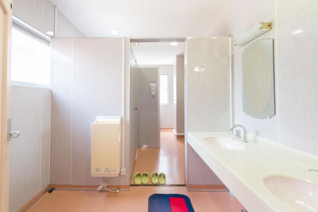 une salle de bain avec un lavabo et un miroir dans l'établissement Yamamoto Ryokan, à Fukuoka 29 autres photos