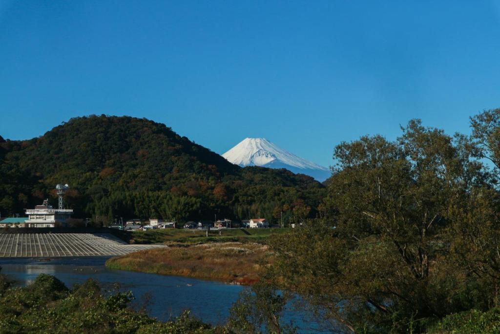 une montagne au loin avec une rivière et des arbres dans l'établissement Sanyo-so, à Izunokuni