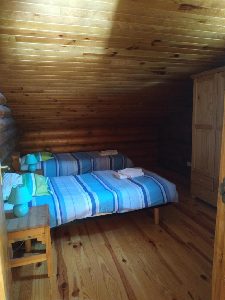 un lit dans une chambre avec un plafond en bois dans l'établissement CHALET DE L'OURS, à Saint-Pierre-dels-Forcats