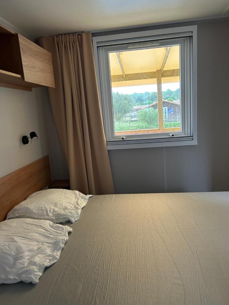 un lit dans une chambre avec une fenêtre dans l'établissement Un été au Cap Ferret, à Lège-Cap-Ferret 14 autres photos