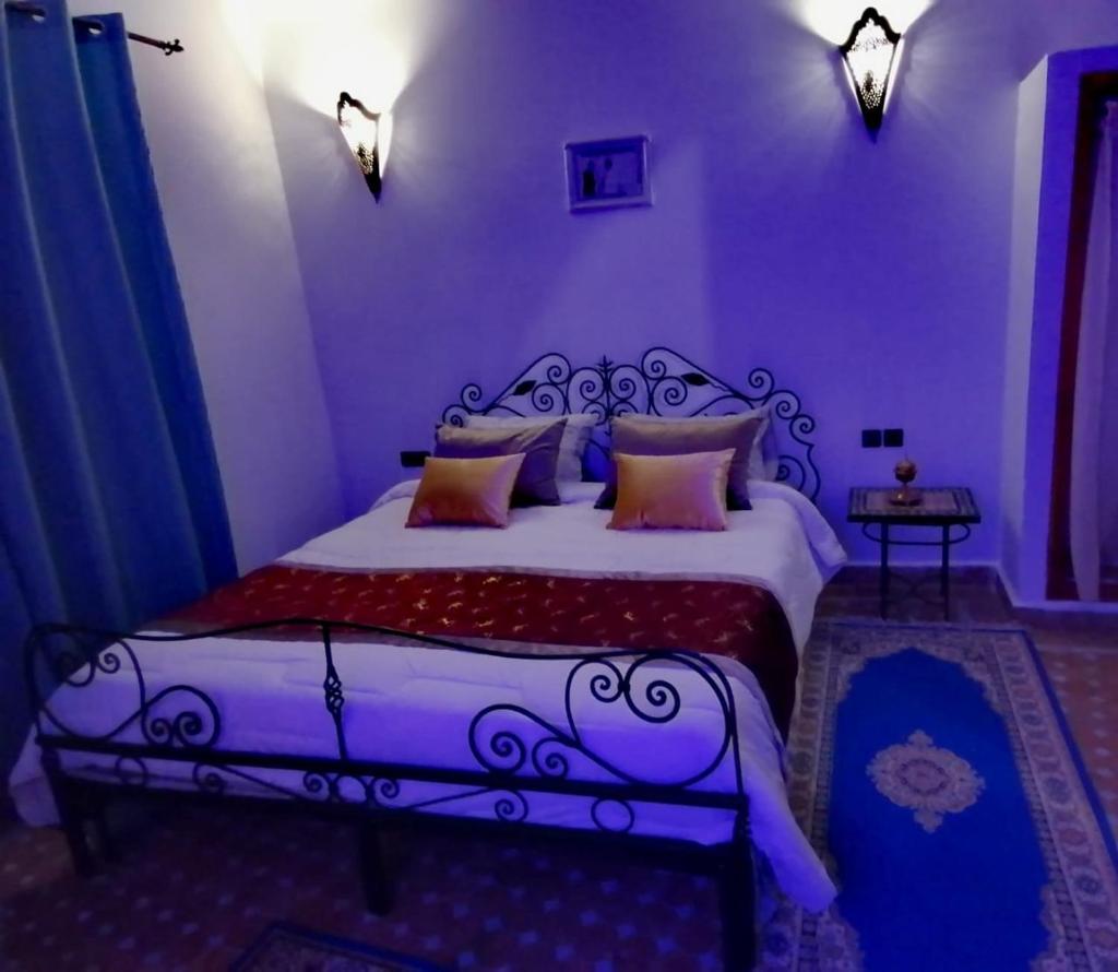 une chambre avec un grand lit dans une pièce dans l'établissement Al Andaloussiya Diyafa, à Moulay Idriss Zerhoun