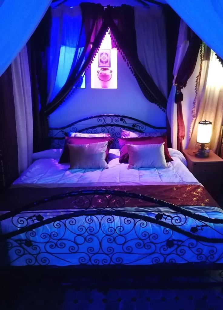 une chambre avec un lit à baldaquin dans l'établissement Al Andaloussiya Diyafa, à Moulay Idriss Zerhoun 37 autres photos