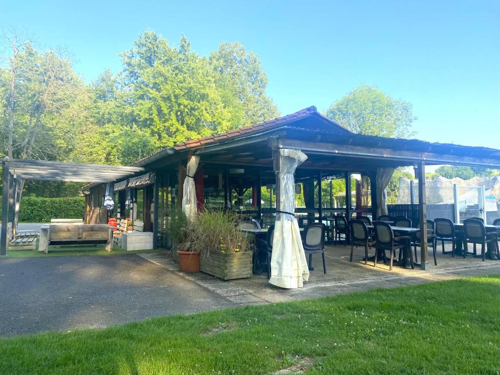 - un pavillon avec des tables et des chaises dans la cour dans l'établissement Camping L'Etruyere, à La Tardière 7 autres photos