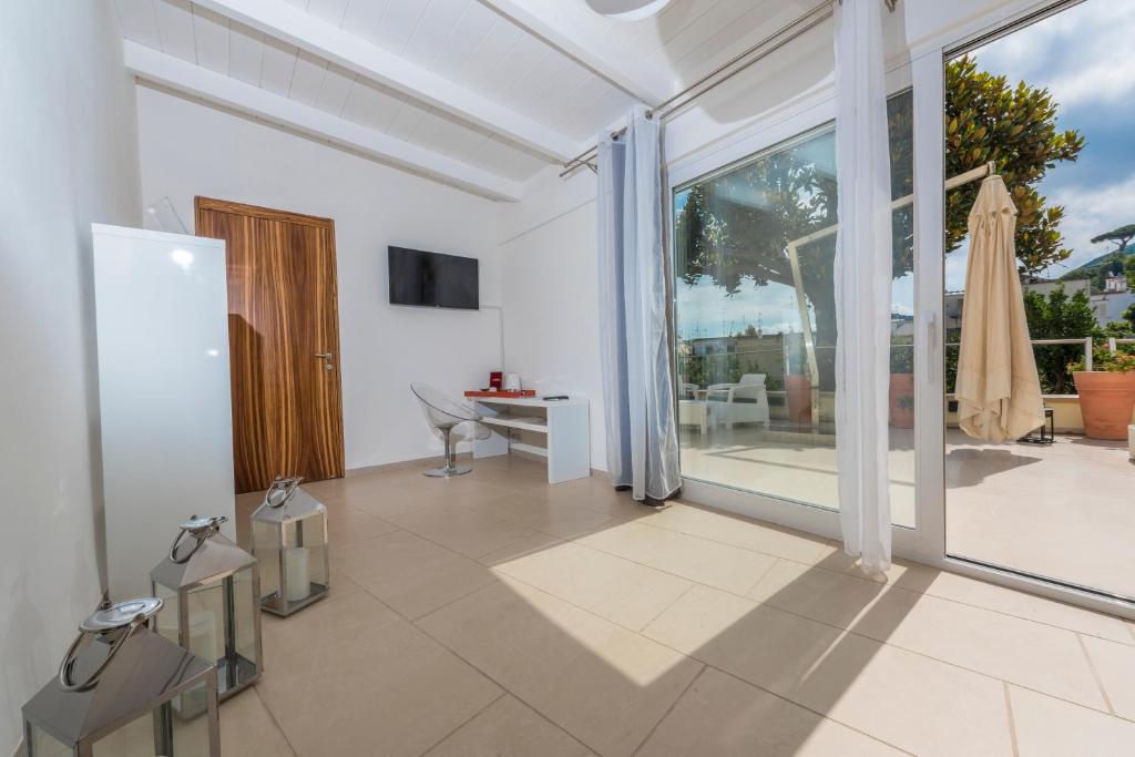 - un salon avec une porte coulissante en verre et une table dans l'établissement Marina 10 Design Hotel & SPA, à Ischia