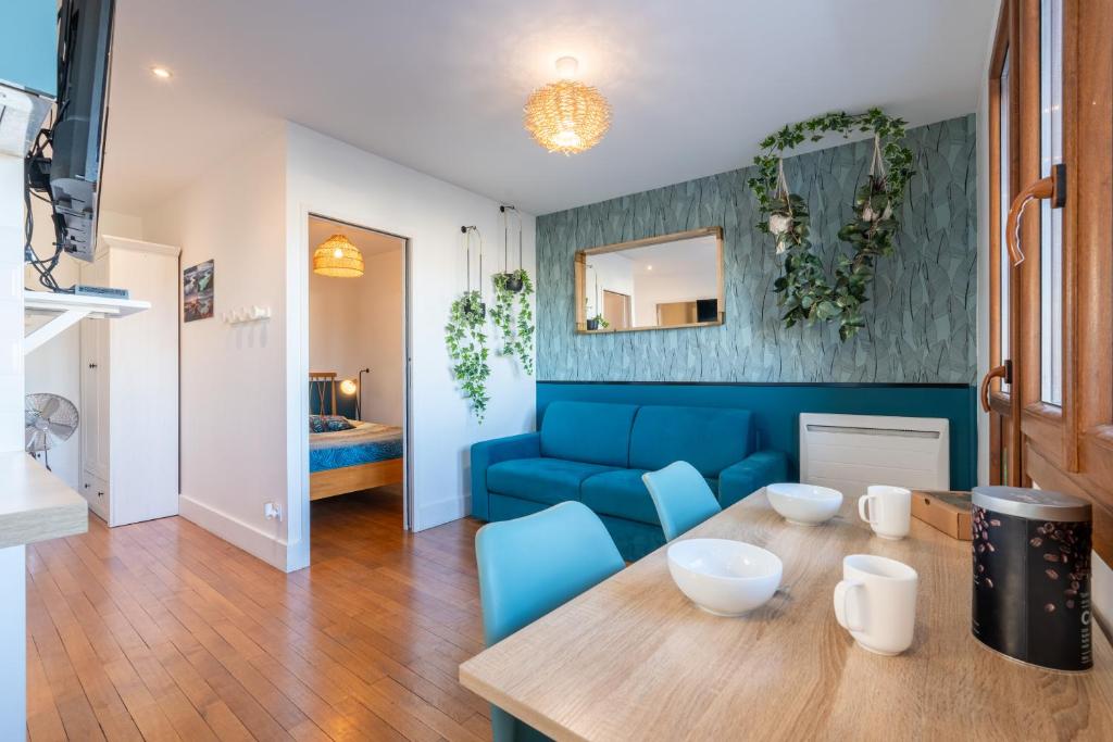 un salon avec un canapé bleu et une table dans l'établissement La station n° 5, à Annecy