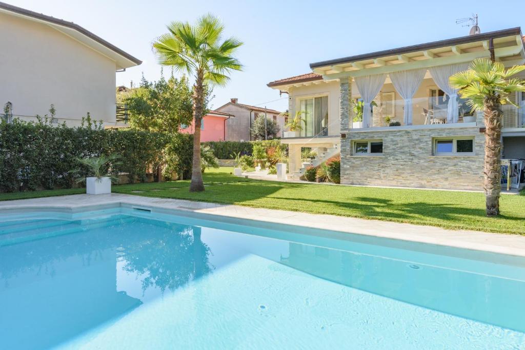 une grande piscine devant une maison dans l'établissement Villa Fiumetto by Mmega, à Querceta