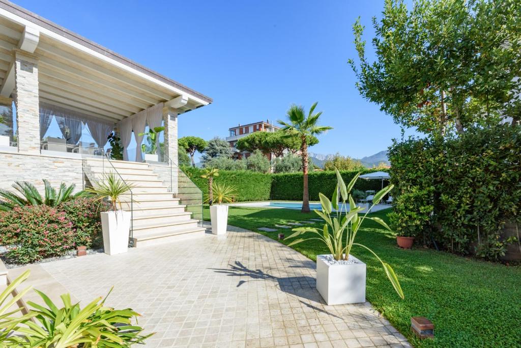une maison avec des escaliers et des plantes dans une cour dans l'établissement Villa Fiumetto by Mmega, à Querceta