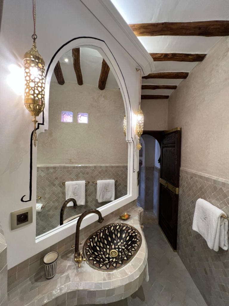 une salle de bain avec un lavabo et un miroir dans l'établissement Riad Des Arts, à Marrakech