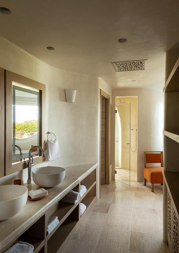 une salle de bain avec deux lavabos et une douche dans l'établissement Romazzino, A Belmond Hotel, Costa Smeralda, à Porto Cervo