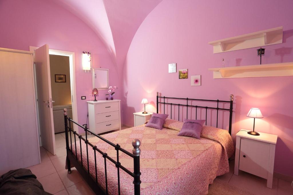 - une chambre avec des murs violets et un lit avec des oreillers violets dans l'établissement Villa Fenice, à Calatabiano