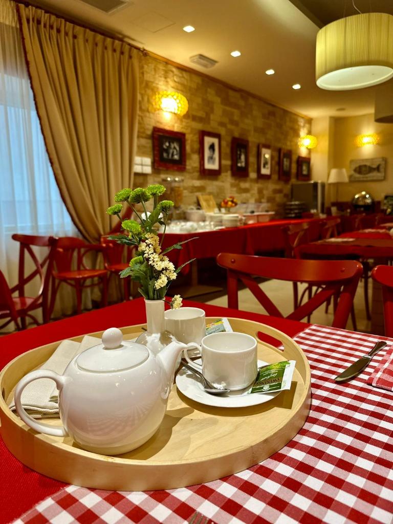 - une table avec une théière et des tasses sur un plateau dans l'établissement Relais Concorde, à Grottammare