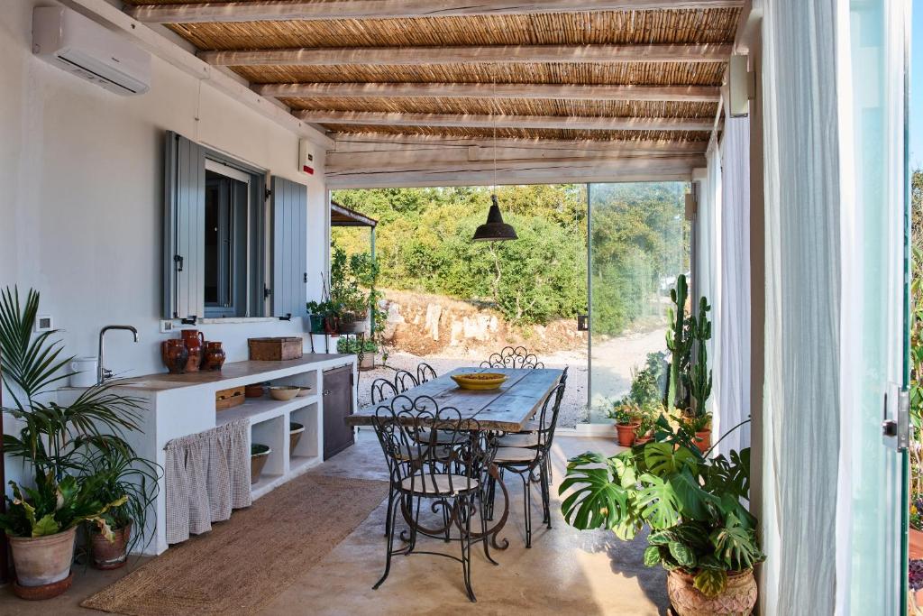 une cuisine avec une table et des chaises sur une terrasse dans l'établissement La Selvaggia Ostuni - w pool, à Ostuni