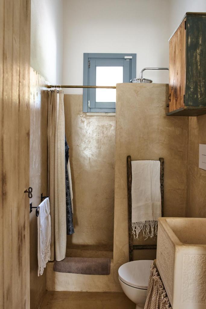 une salle de bain avec toilettes, lavabo et fenêtre dans l'établissement La Selvaggia Ostuni - w pool, à Ostuni